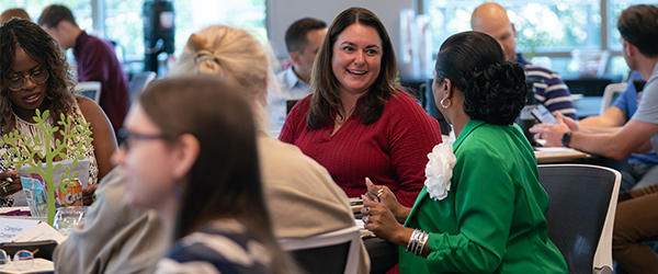 A group of IGS Energy employees sit together at a table during an on-site event