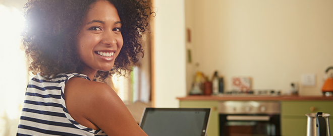 Smiling woman using a laptop)