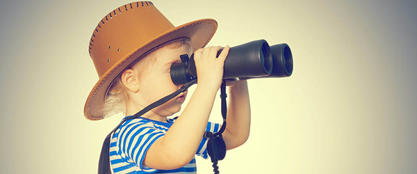 Child in hat looking through binoculars 