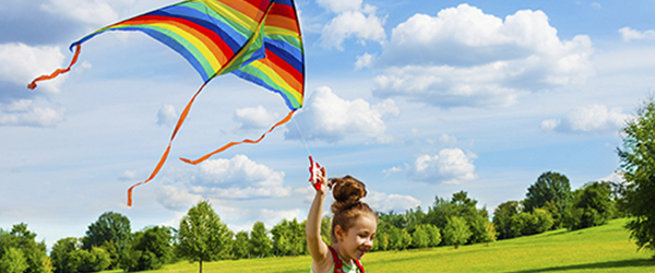 Girl flying a kite in the park)