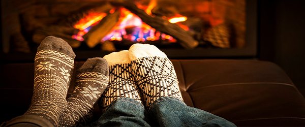 Socked feet warming by a fire