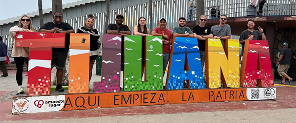 9 IGS Energy employees post in Tijuana, Mexico, at the start of the Fall 2025 Renewable Energy Crops trip.)